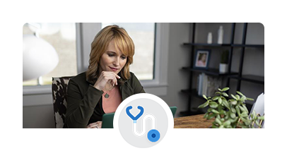A smiling patient sitting in her home office in front of her laptop on a virtual call.