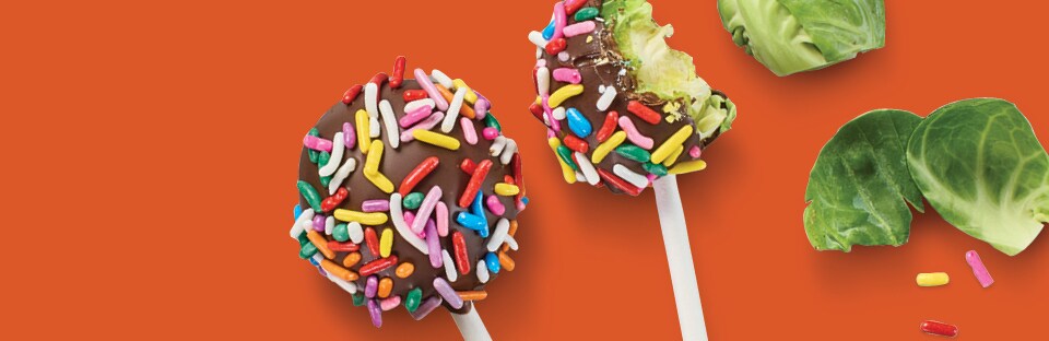 brussels sprouts covered in melted chocolate and rainbow sprinkles that look like cake pops