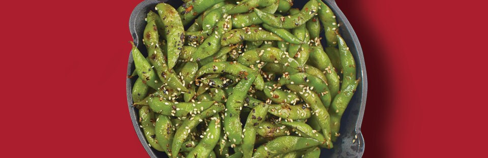 garlic flavored edamame in cast iron skillet