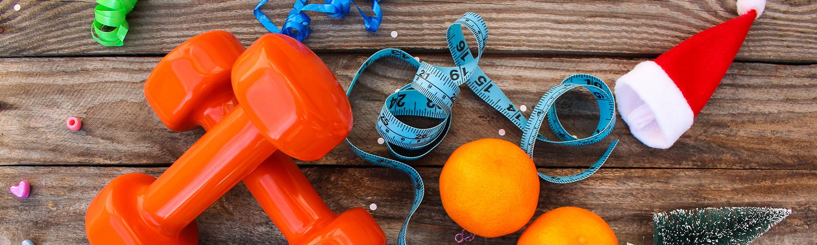 Weights and oranges on a wooden table to stay healthy