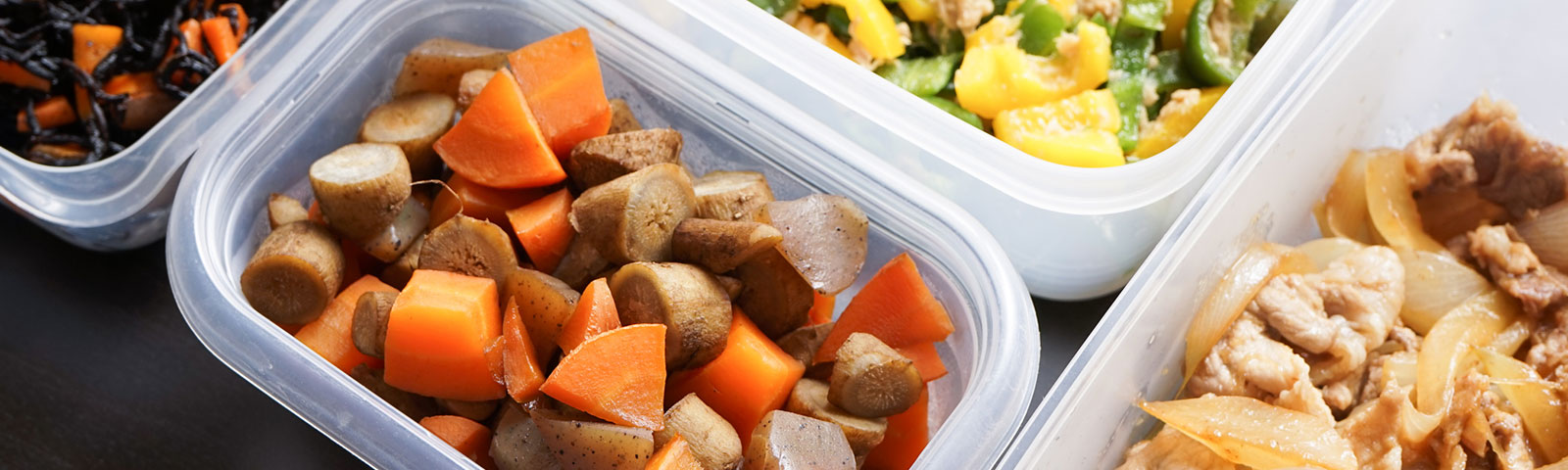 Multiple plastic food containers full of various chopped vegetables