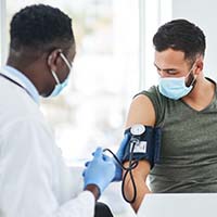 A clinician taking a patient's blood pressure. A clinician taking a patient's blood pressure.