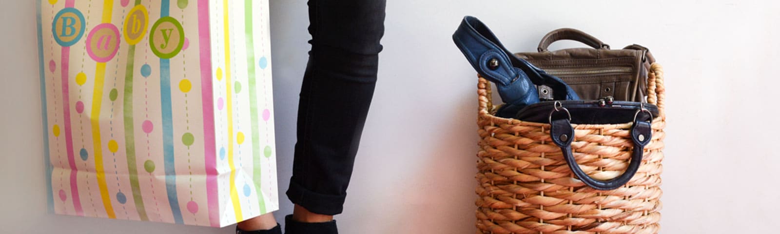 Person standing with baby bag and black skinny jeans