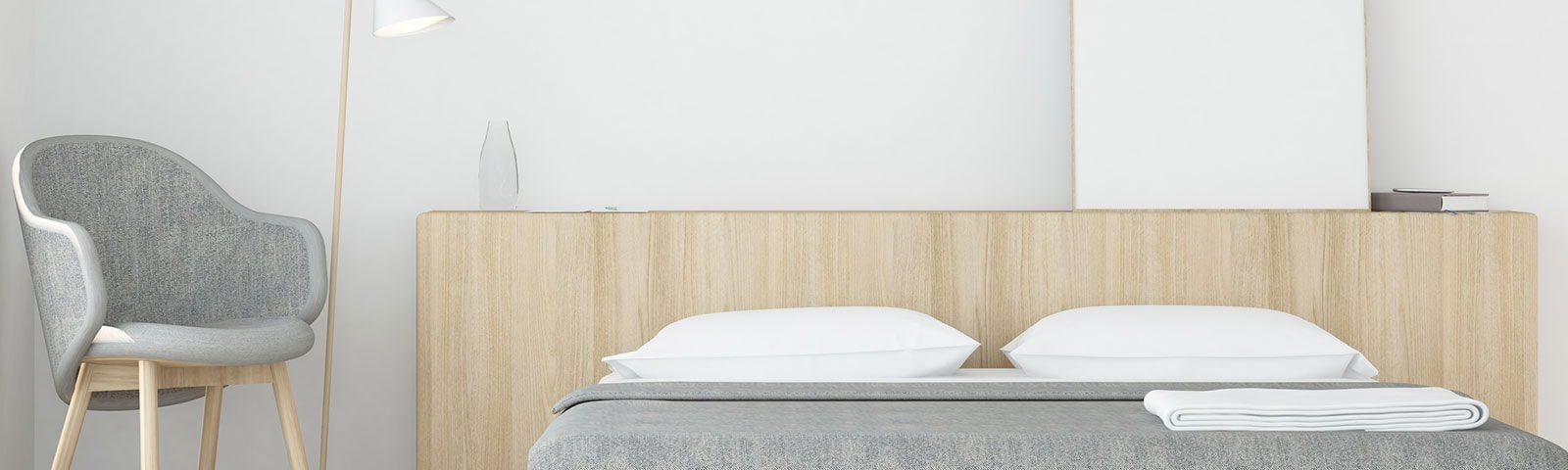 Clean, minimalist bedroom with a grey chair, lamp and bed set