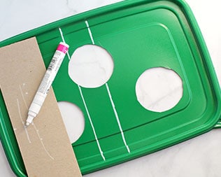 Green rectangle container lid with three holes cut out