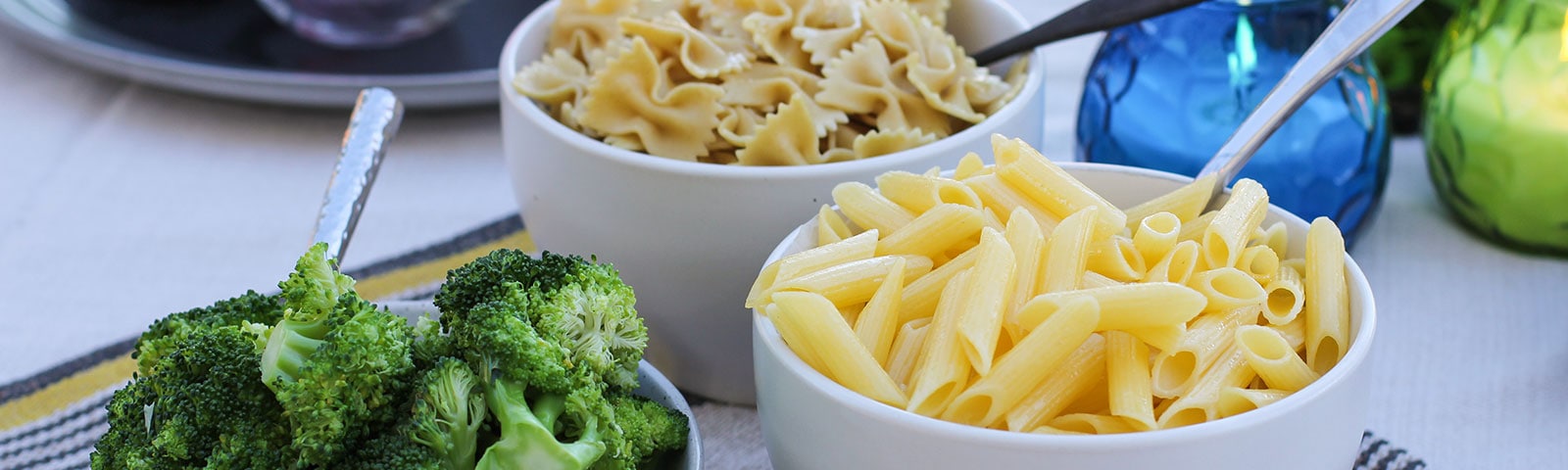 Cooked pasta and broccoli  in separate bowls