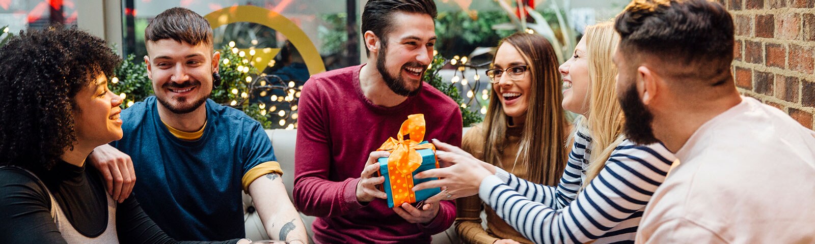 A group of friends exchanging gifts at a restaurant