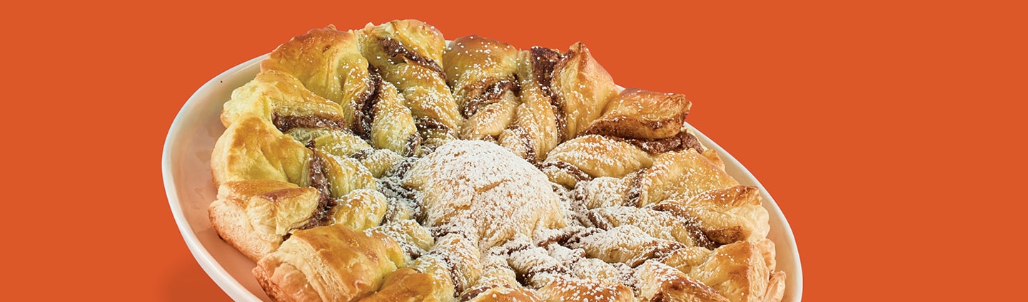 puff pastry snowflake with confectioners’ sugar falling down