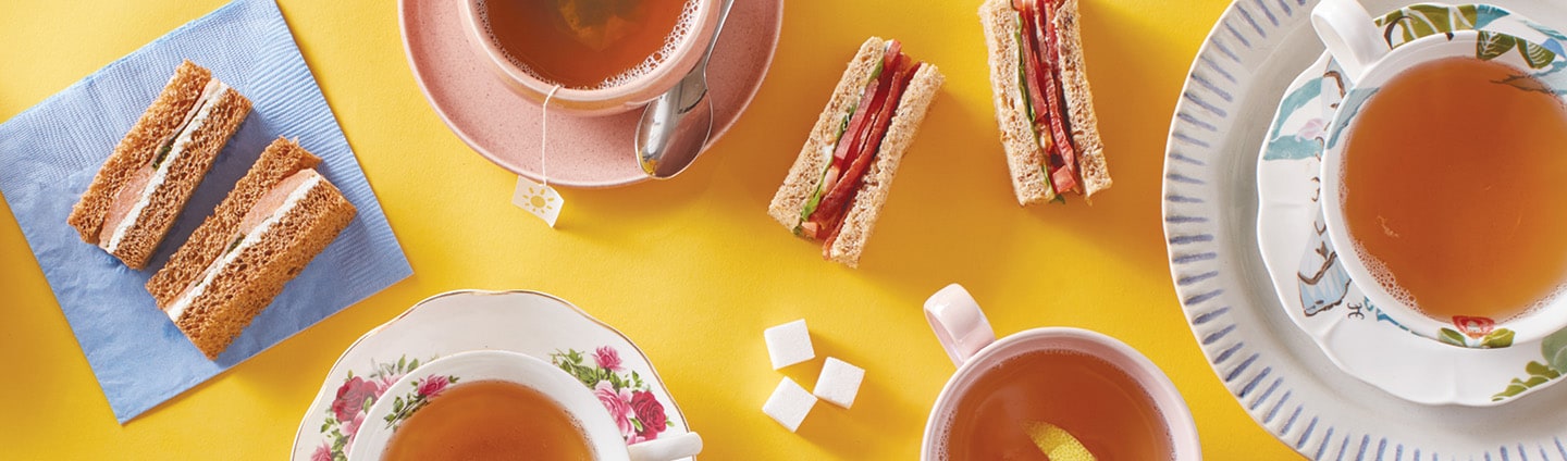 overhead table showing tea cups and tea sandwiches
